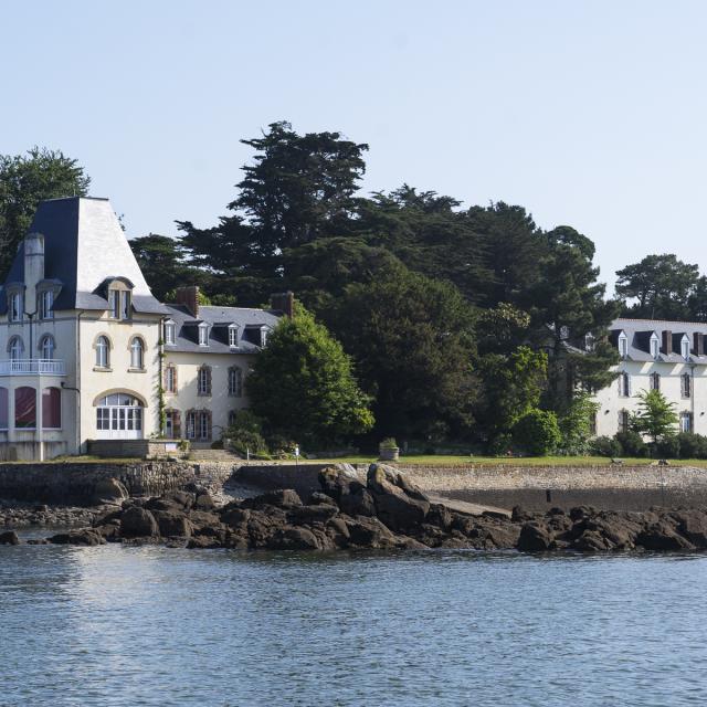 Vue sur les quais de l'île Tristan depuis le port de plaisance de Tréboul. 2 bâtiments sur les quais dont une belle maison de maître